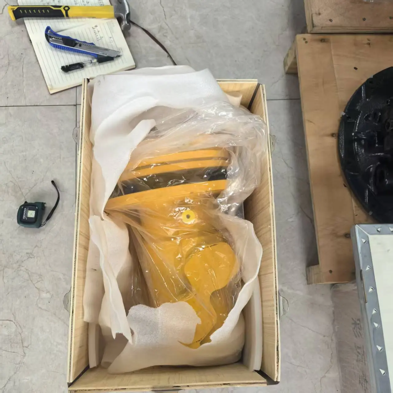 Excavator part protected with wrapping and cushioning before packing